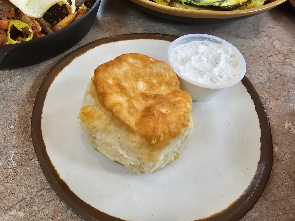 A biscuit split open with herb cream dip at 43rd Street Deli
