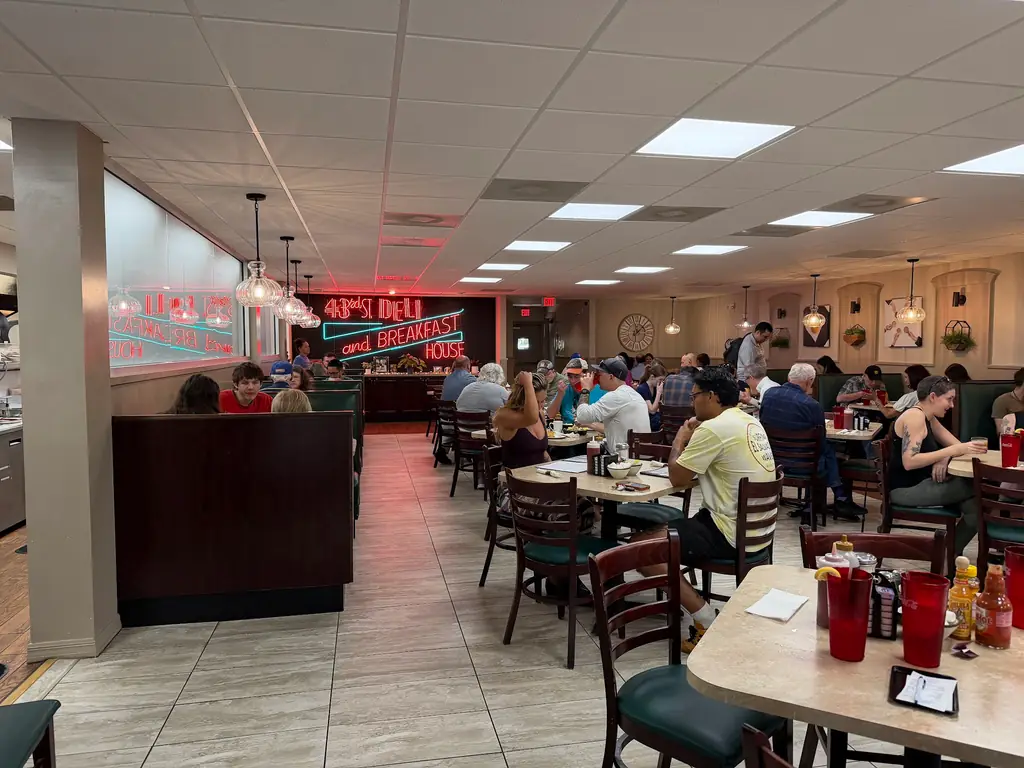 The dining room at 43rd Street Deli full of customers under the neon sign